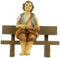 Preview: Handbemalte Krippenfigur Junge sitzend inkl. Bank, ca. 9 cm, K 001-28